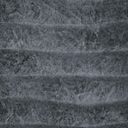 Grey sculpted table lamp base with ridged texture under fabric shade