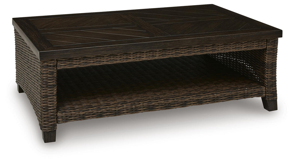 Dark brown rectangular table with woven wicker sides and open lower shelf