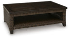 Dark brown rectangular table with woven wicker sides and open lower shelf