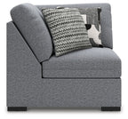 Gray upholstered wedge armchair with side arm and patterned throw pillows