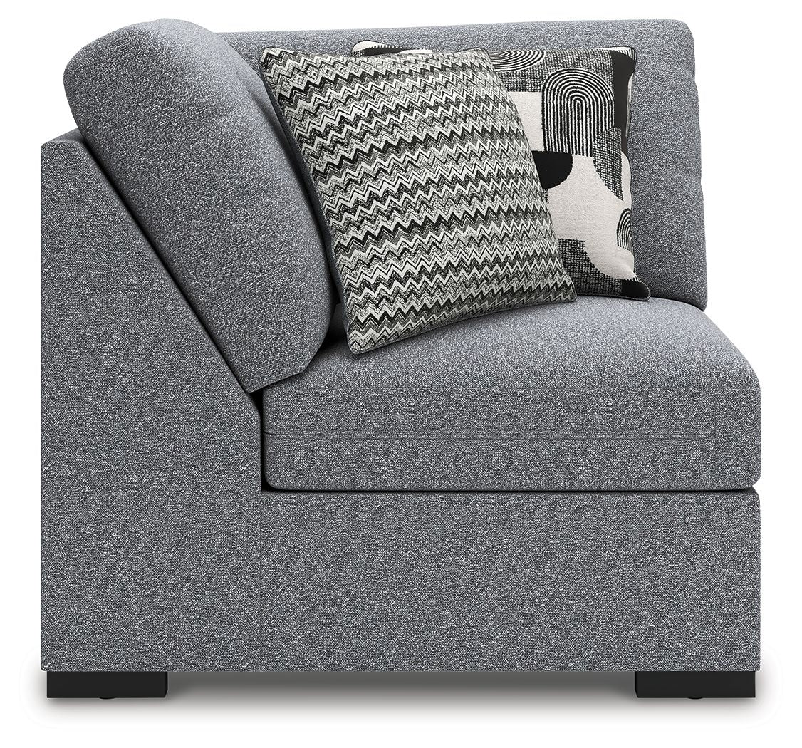 Gray upholstered wedge armchair with side arm and patterned throw pillows