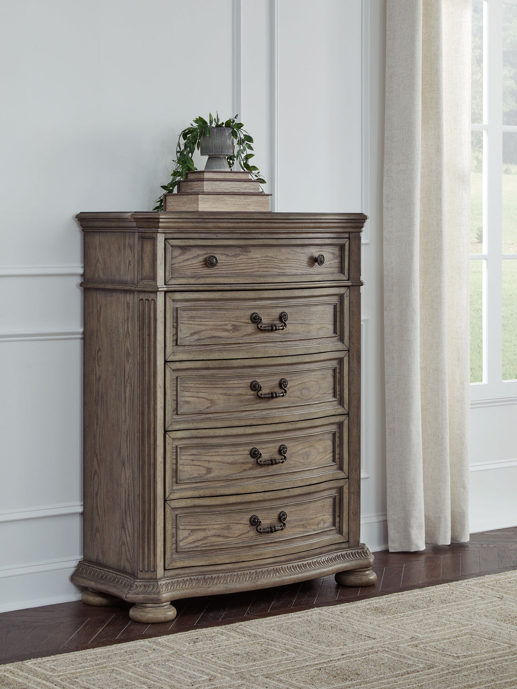 Light brown five-drawer chest with dark metal handles and stacked drawer design
