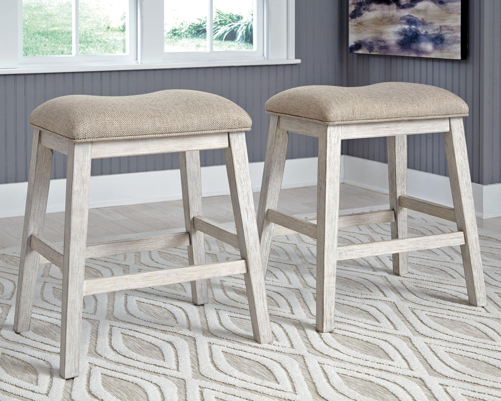 Pair of beige upholstered vanity stools with curved seat tops and matching wood footrest
