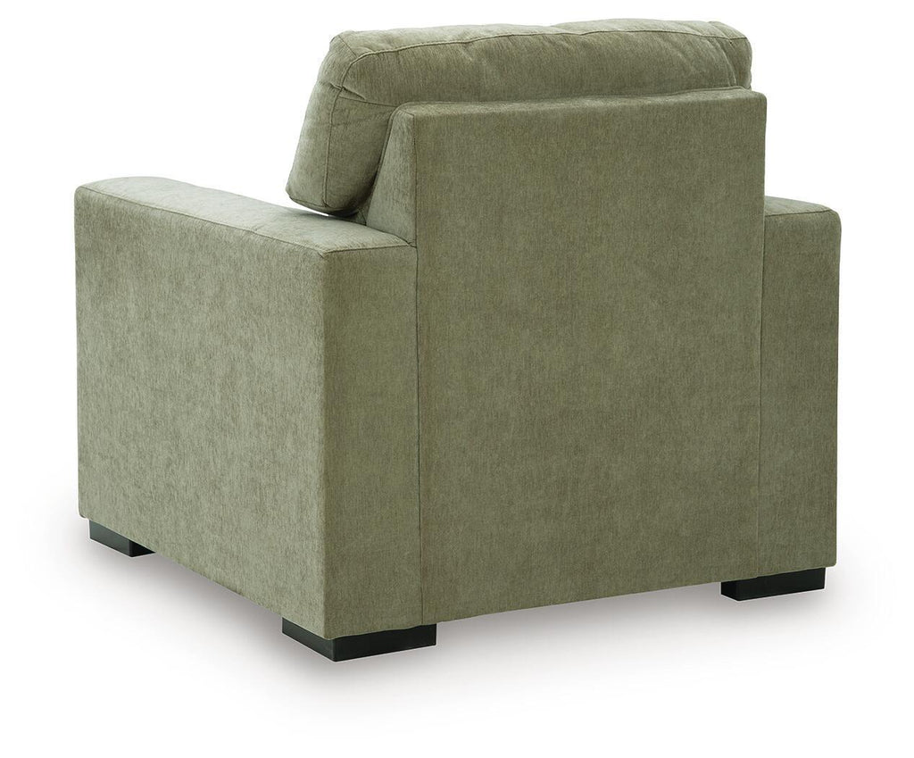 Moss green upholstered armchair with rounded back cushion and block feet