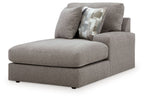 Smoke gray corner chaise with curved armrest and patterned throw pillow