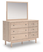 Tan wood dresser with wall mirror and floral-pattern drawer fronts, angled view
