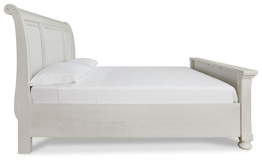 White sleigh bed with rounded headboard and low footboard, simple wood frame.