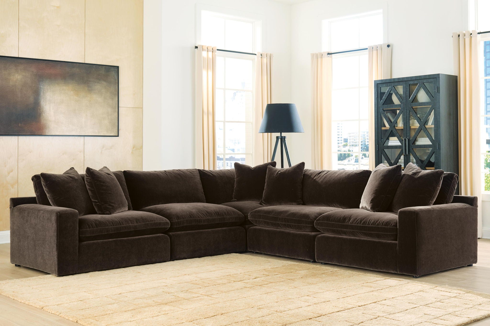 Dark brown sectional sofa with thick seat cushions, square arms, and back cushions with pillows.