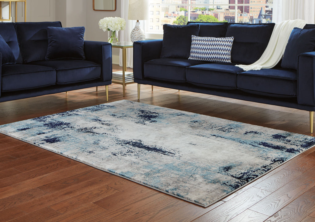 Abstract blue and gray area rug with distressed border and worn pattern