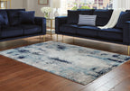 Abstract blue and gray area rug with distressed border and worn pattern
