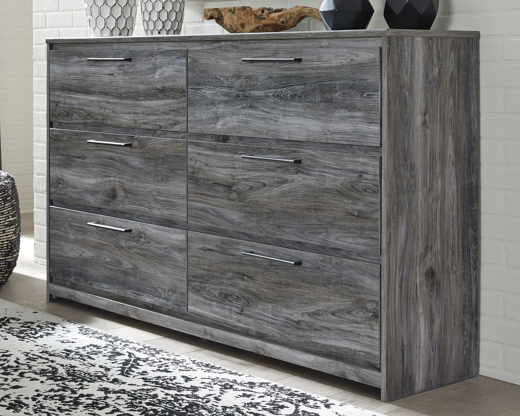 Gray six-drawer dresser with wide side panel and smooth drawer fronts, bar pulls