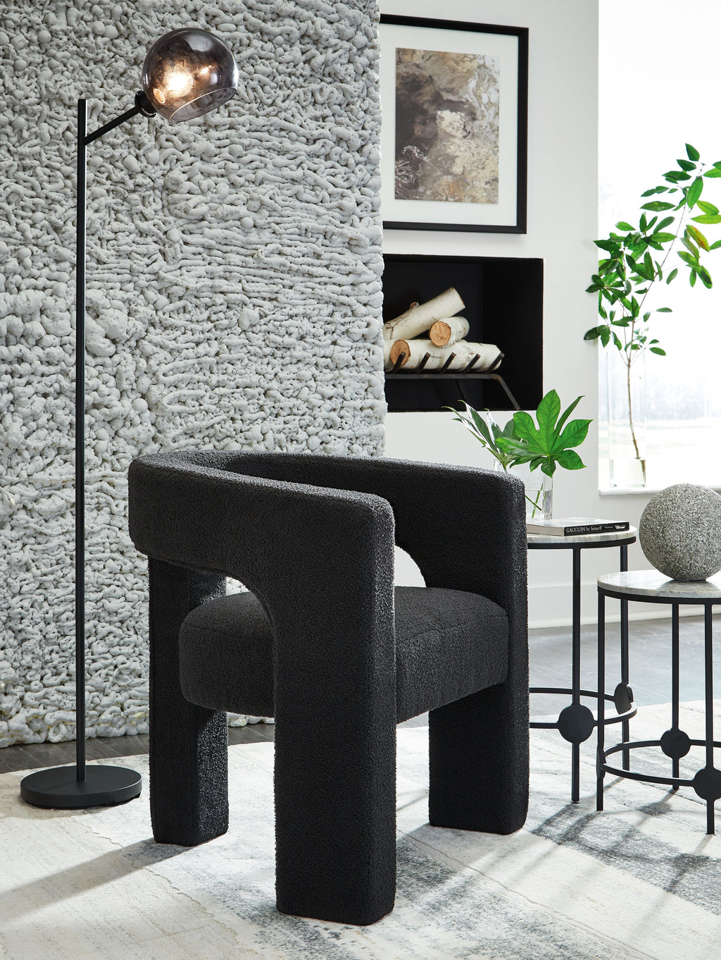 Dark charcoal upholstered accent chair with rounded seat and sturdy block legs