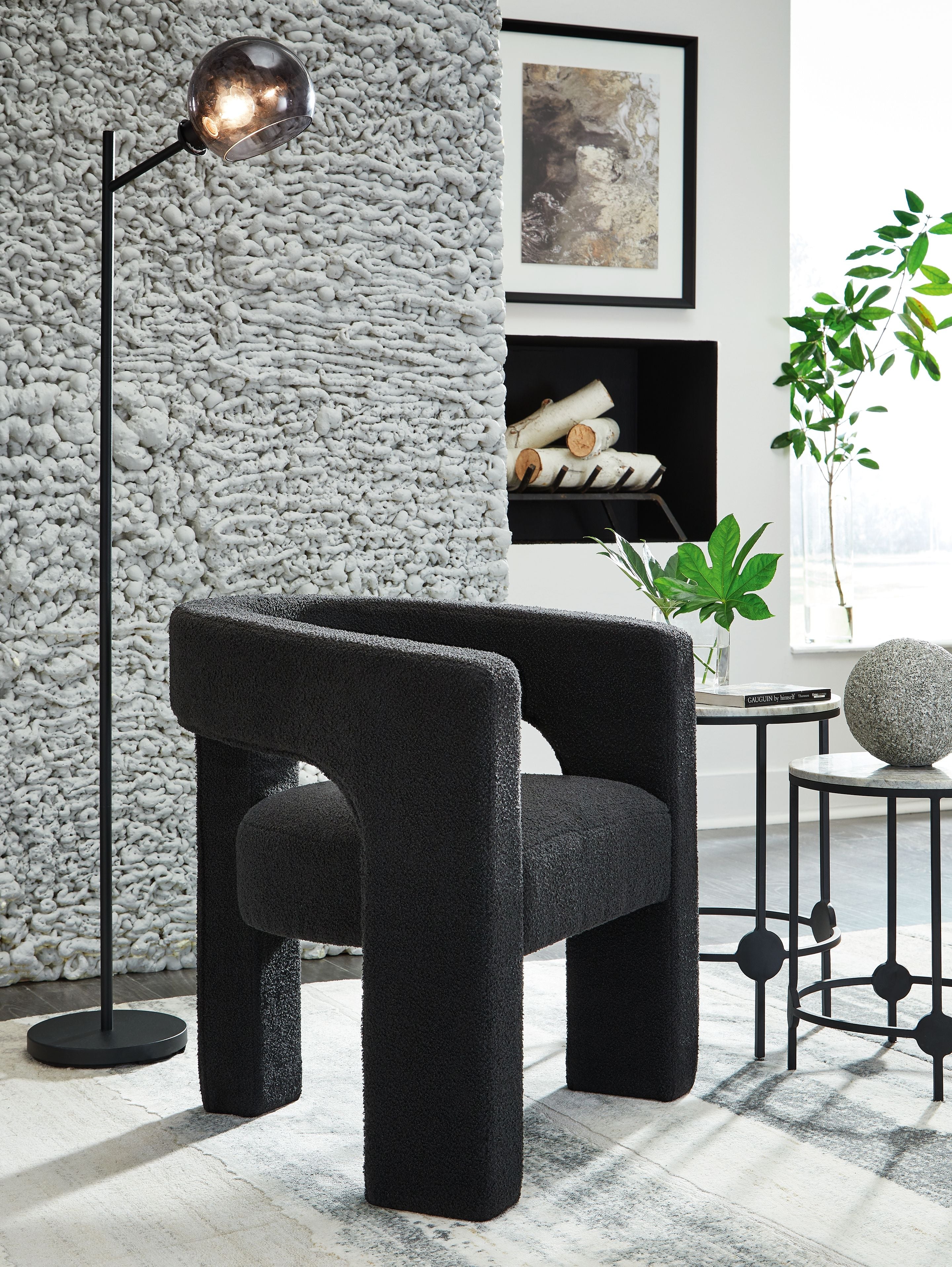 Dark charcoal upholstered accent chair with rounded seat and sturdy block legs