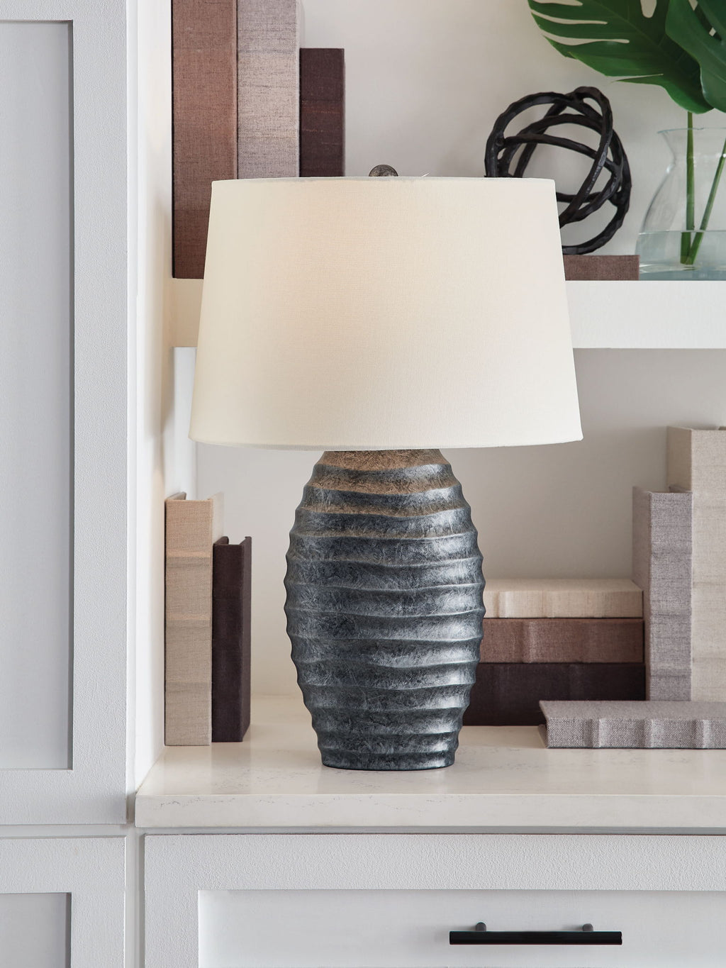 Table lamp with white fabric shade and dark gray ridged ceramic base