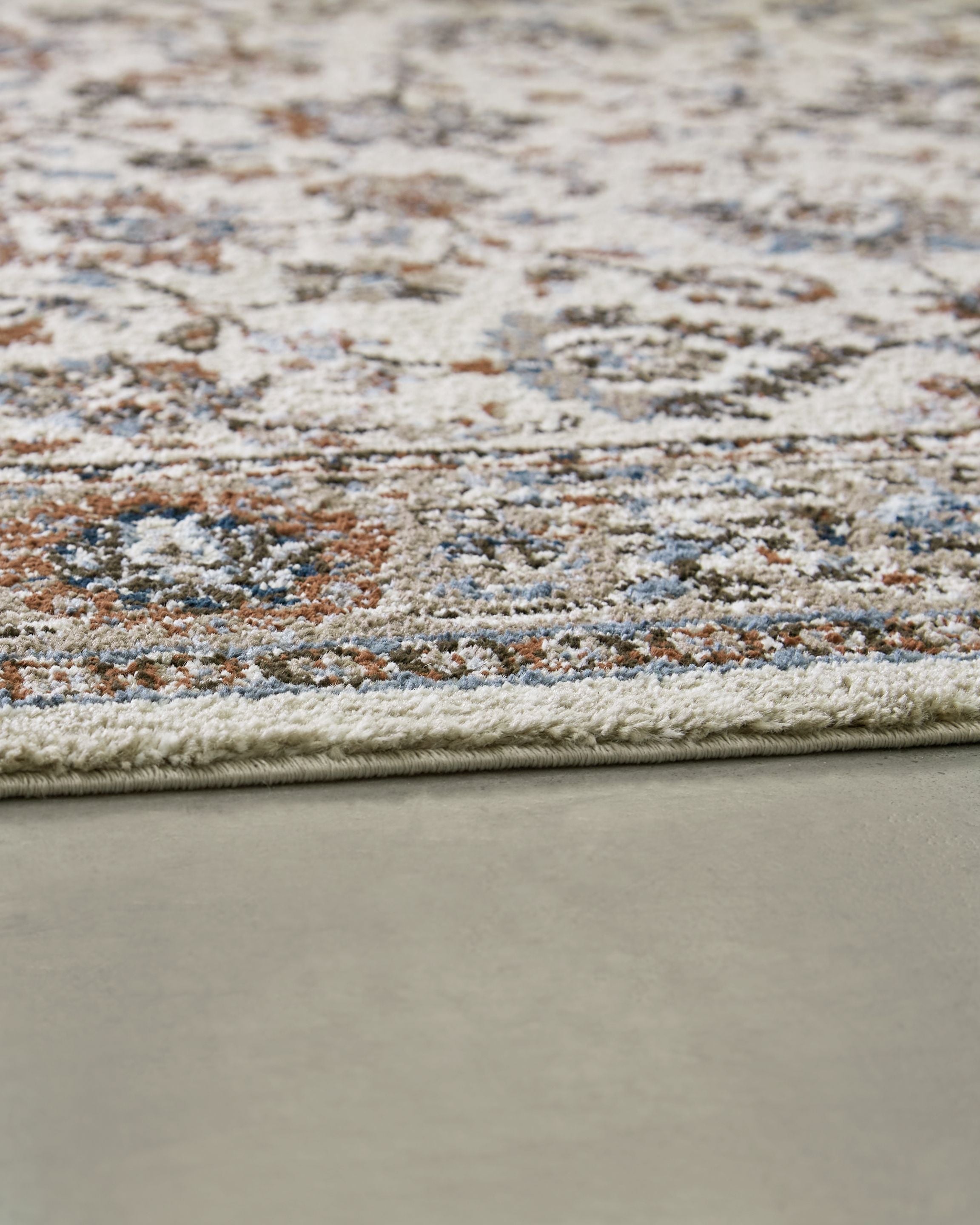 Beritham rug close-up showing dense distressed texture and multicolor speckled floral pattern