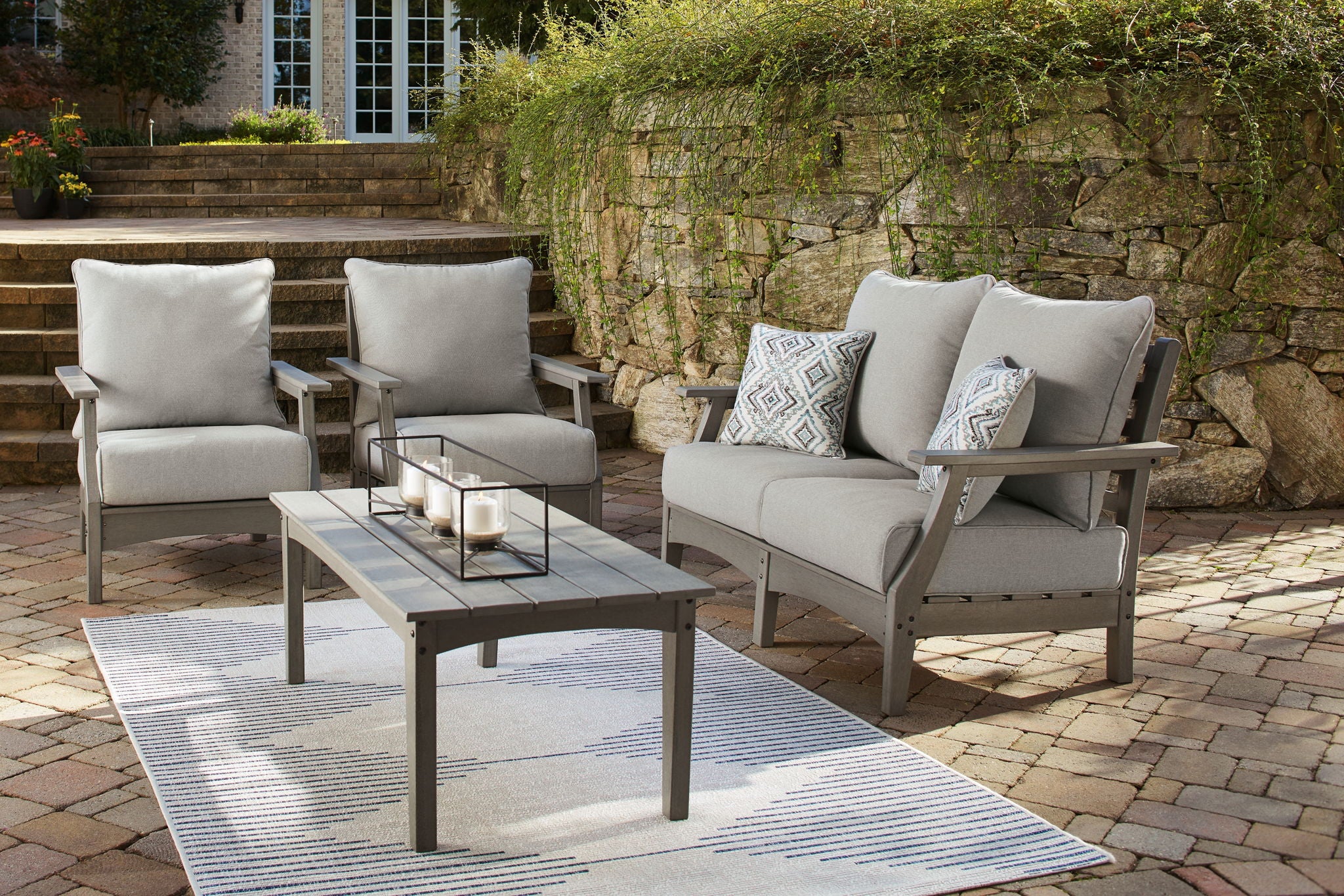 Gray outdoor lounge set with two chairs, sofa seat, and matching coffee table