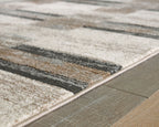 Beige abstract block area rug corner with dark gray stripes and bound edge