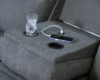 Dark gray recliner console with cup holder and smartphone resting on built-in tray