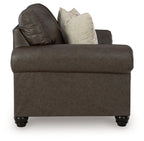Umber loveseat with tufted back, track arms, and two patterned throw pillows