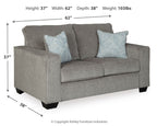 Light gray stationary loveseat with light blue patterned throw pillows and boxed seat cushions