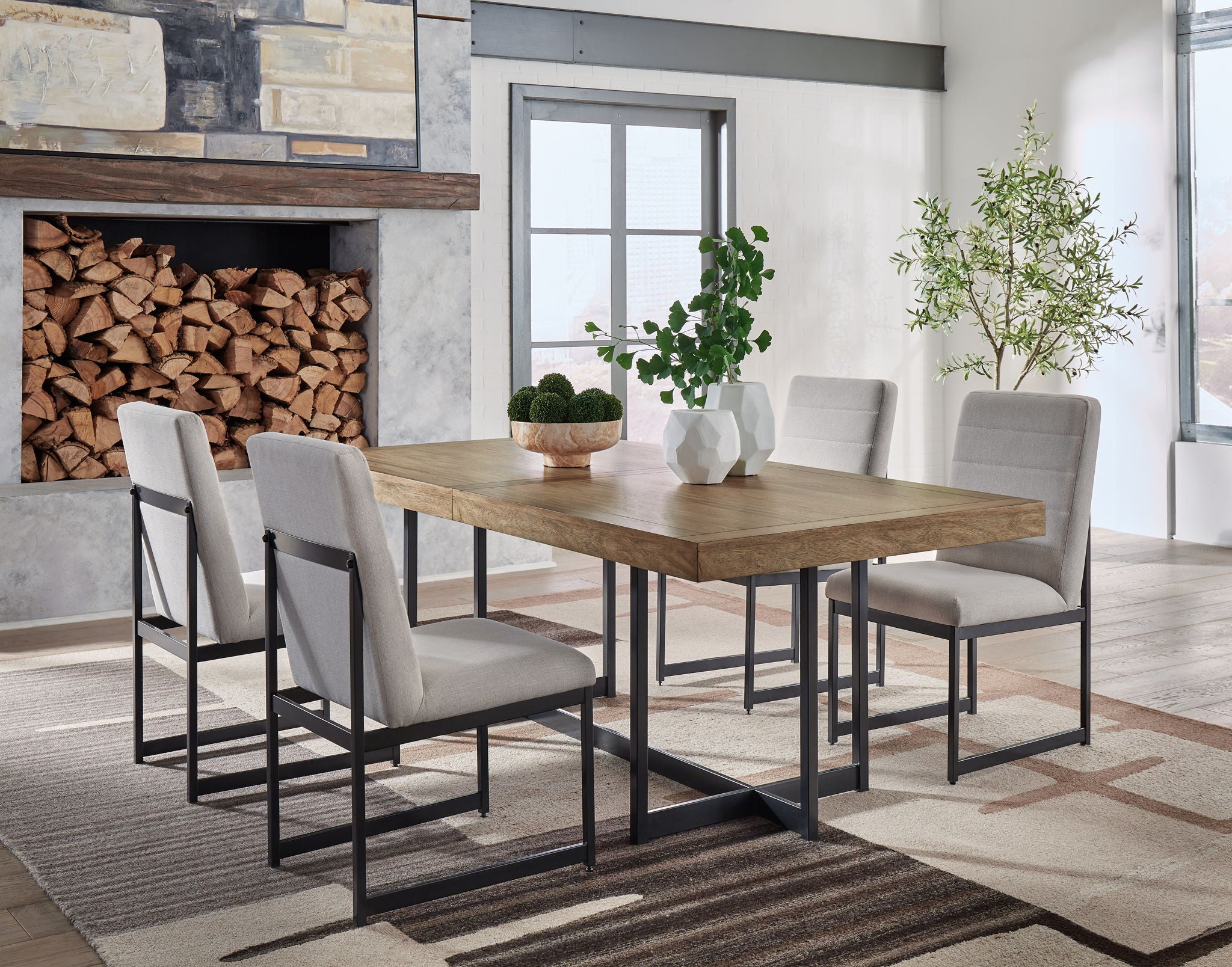 Dining table with light brown top and black metal legs; gray upholstered chairs.
