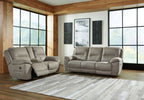 Reclining sofa and loveseat set with light putty gray fabric and cushioned armrests