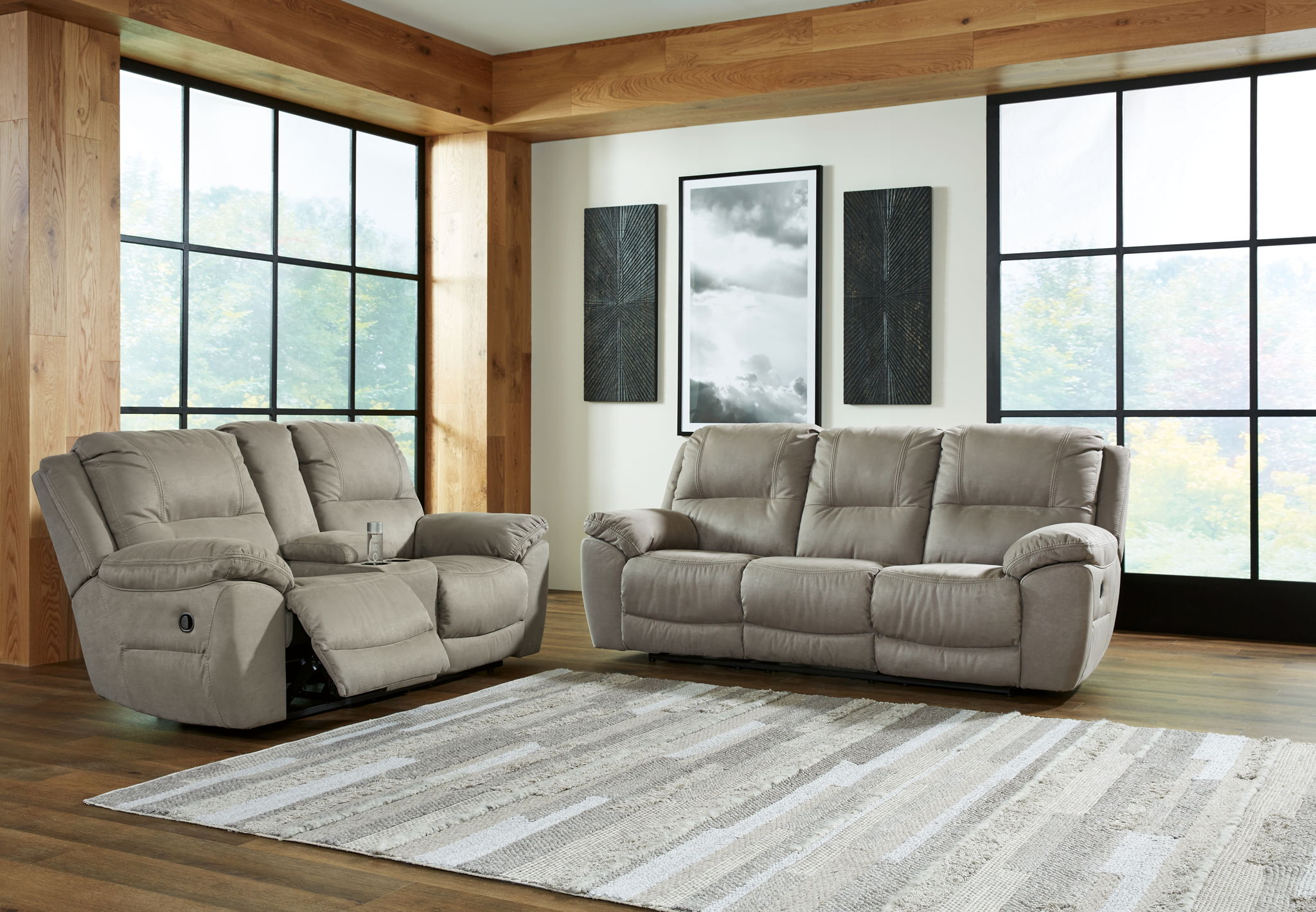 Reclining sofa and loveseat set with light putty gray fabric and cushioned armrests