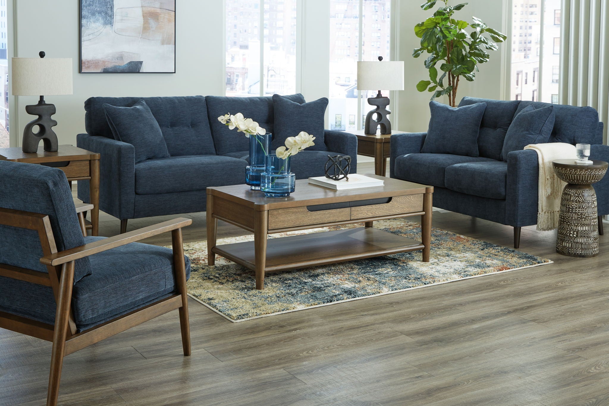 Blue upholstered sofa set with three seating pieces and decorative throw pillows