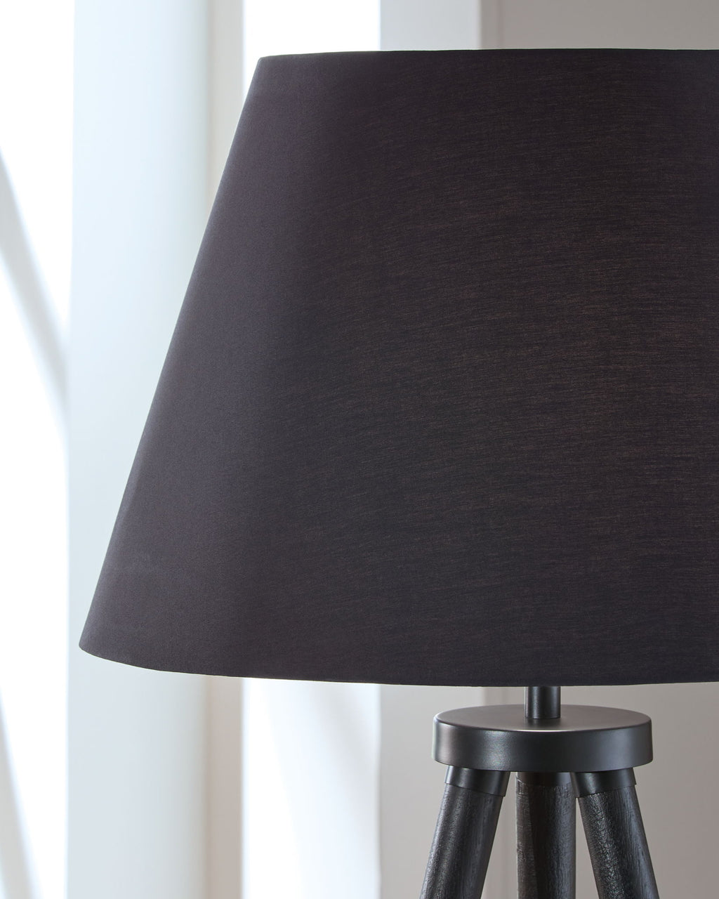 Black conical lamp shade and top cap on three tripod legs