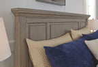 Lettner sleigh bed side panel with blue and cream pillows on gray frame