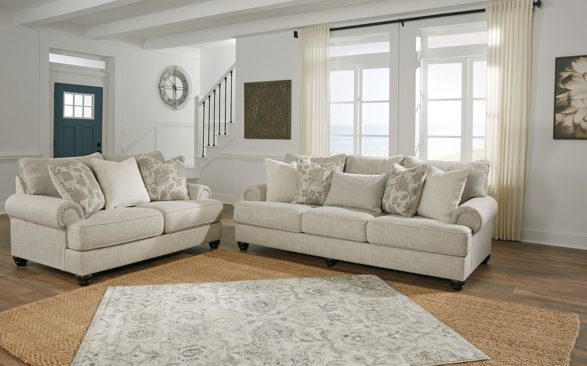 Light gray sectional-style living room set with two sofas and patterned throw pillows