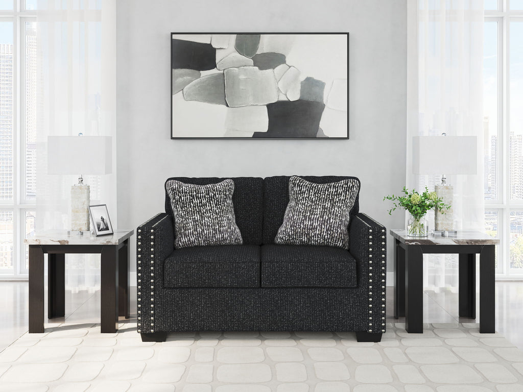 Charcoal loveseat with nailhead trim and two black-and-white patterned throw pillows