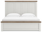 White panel bed with paneled headboard, light wood top rail, cushioned mattress