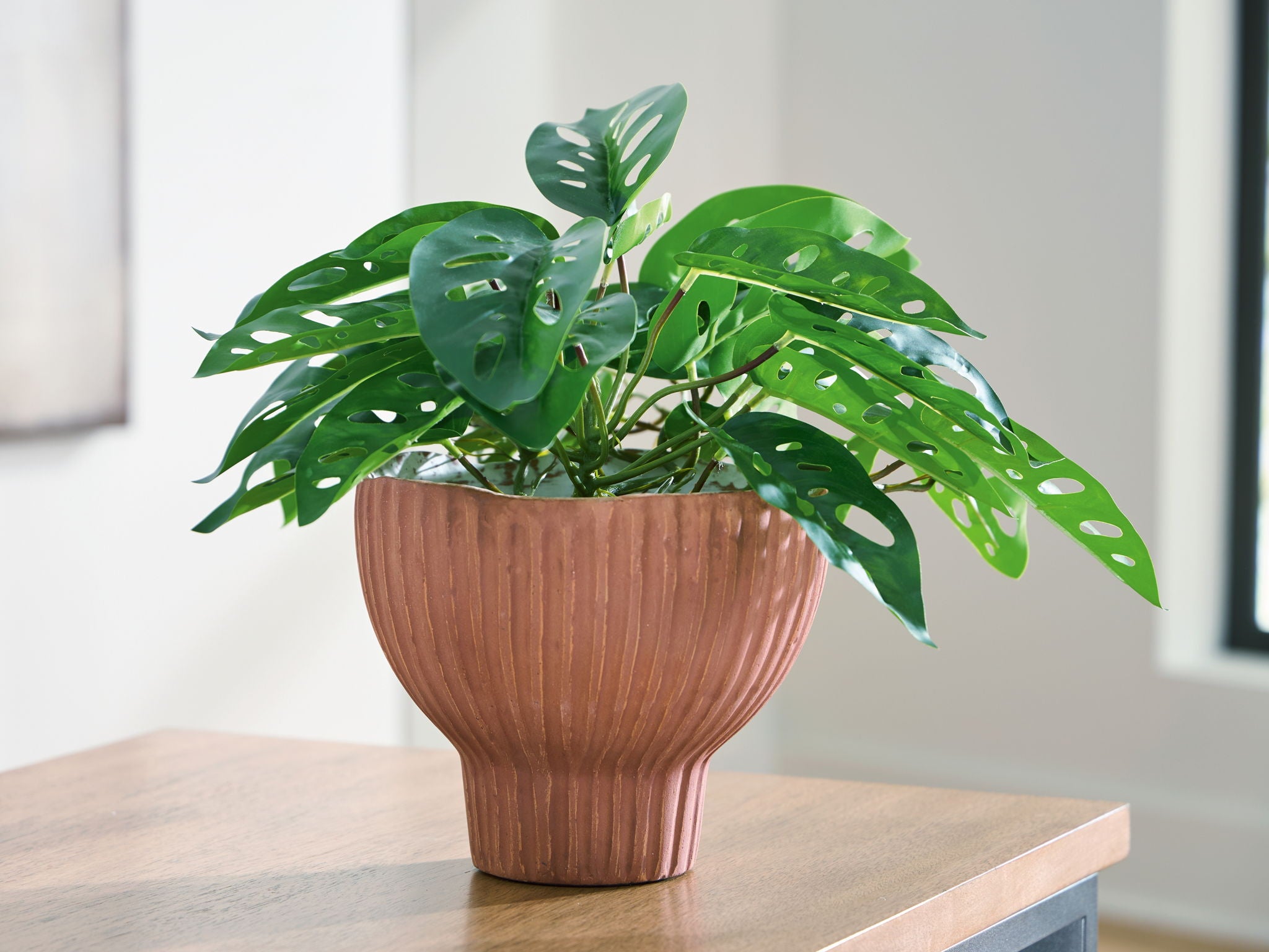 Sienna ribbed vase on tabletop with leafy plant
