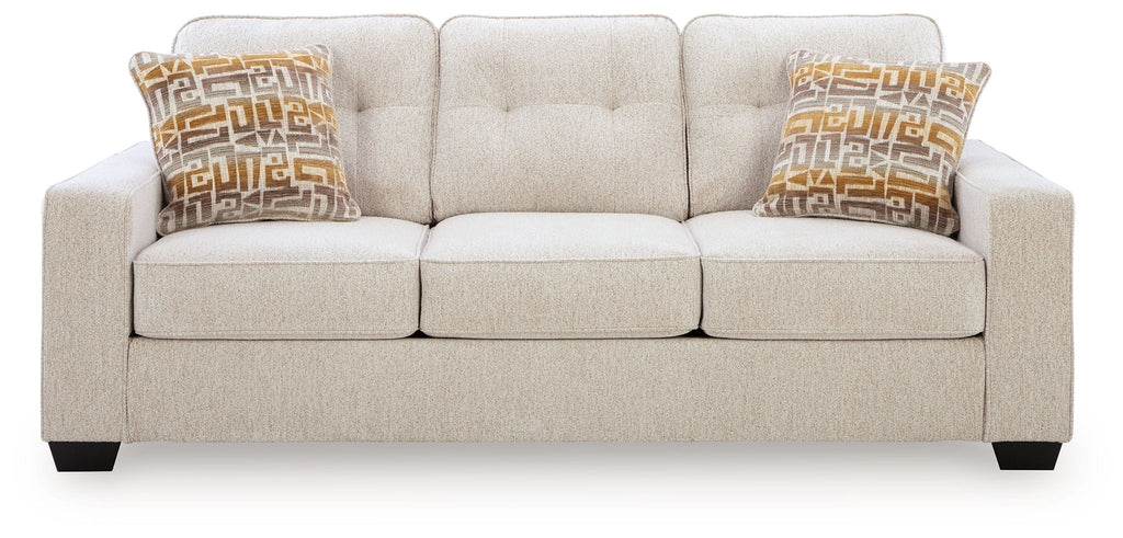 Larimer sofa in beige fabric with tufted back, three seat cushions, and two patterned pillows