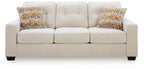 Larimer sofa in beige fabric with tufted back, three seat cushions, and two patterned pillows