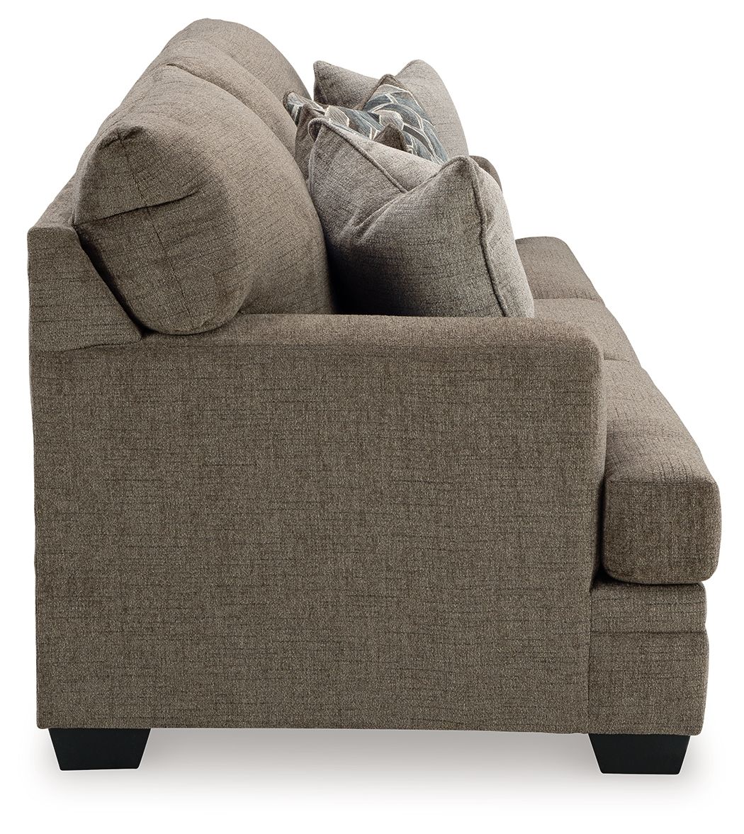 Corner view of a sofa sleeper with taupe upholstery, rounded arms, and two back cushions