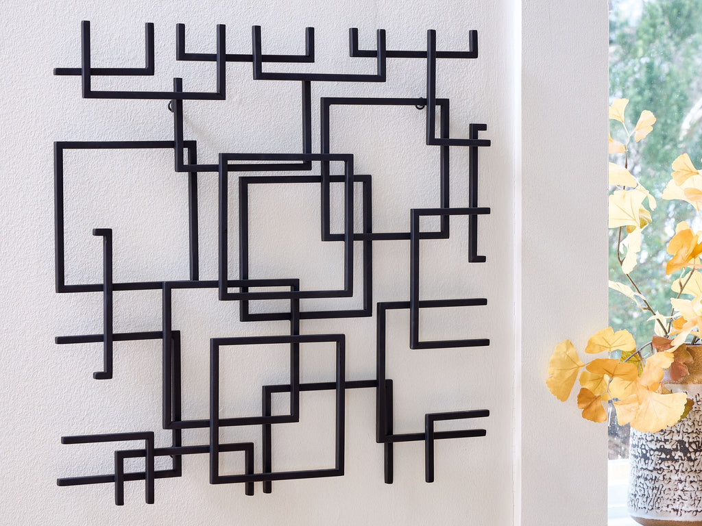Black geometric wall decor with square outlines and bar-like segments in a grid