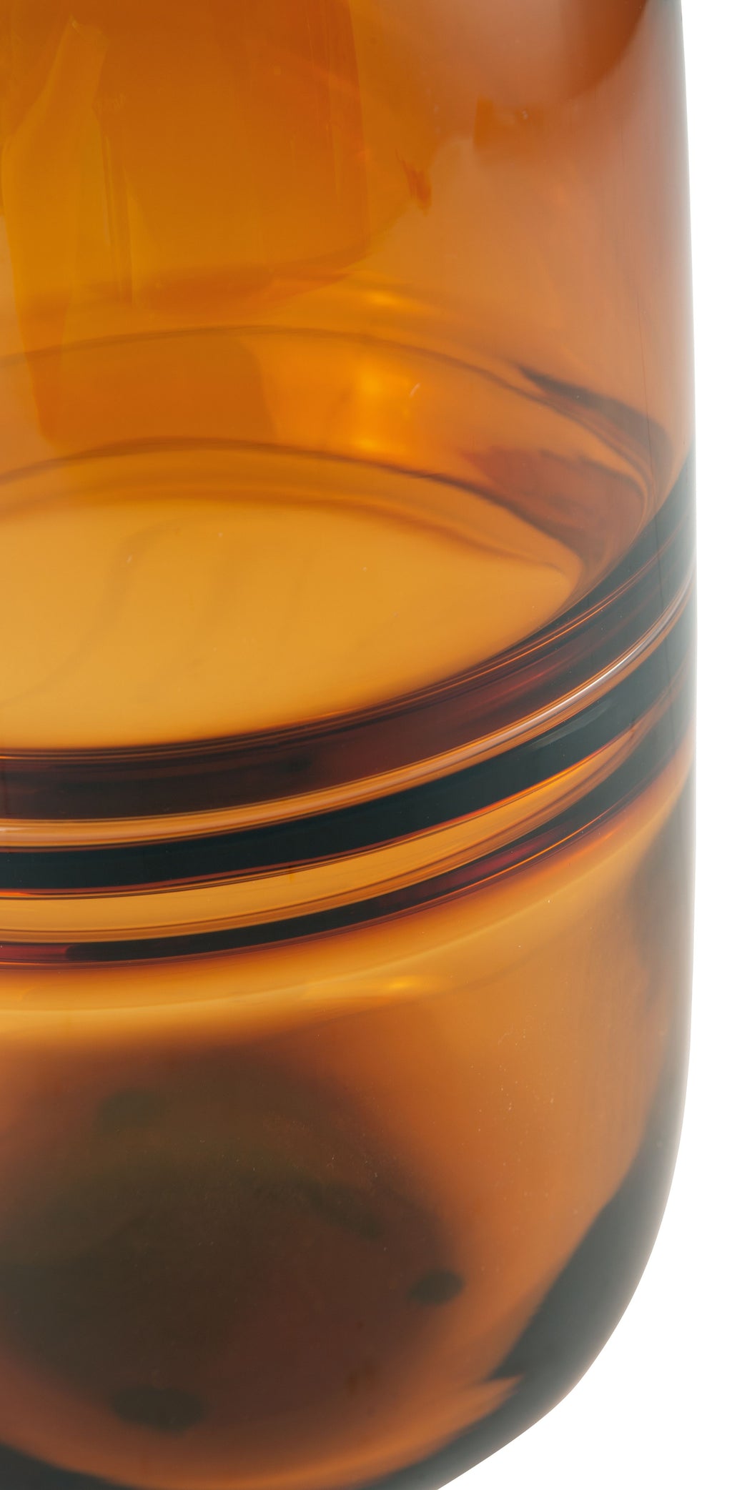 Amber glass vase close-up with horizontal dark bands at the base