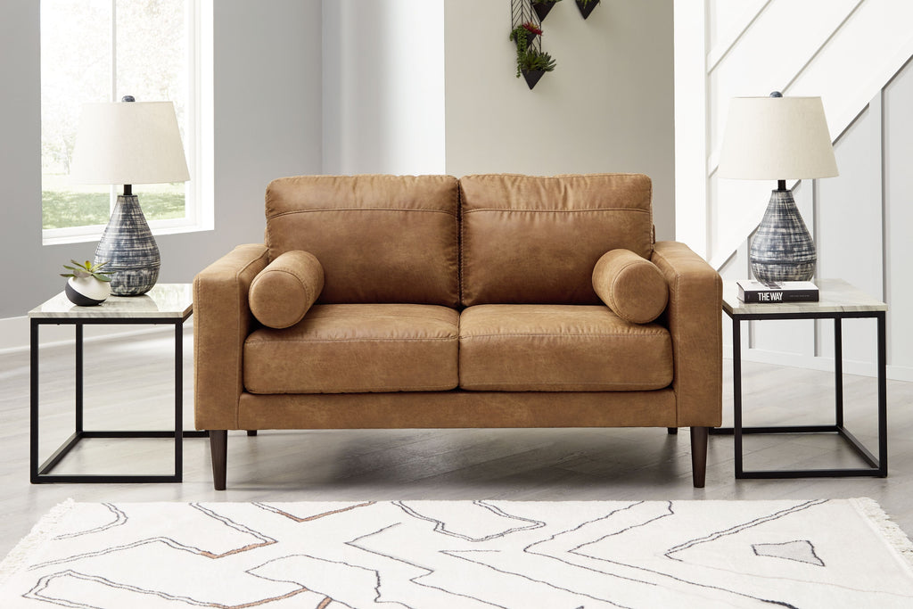Caramel-brown loveseat with two-seat design and rounded rolled arms, styled in room.