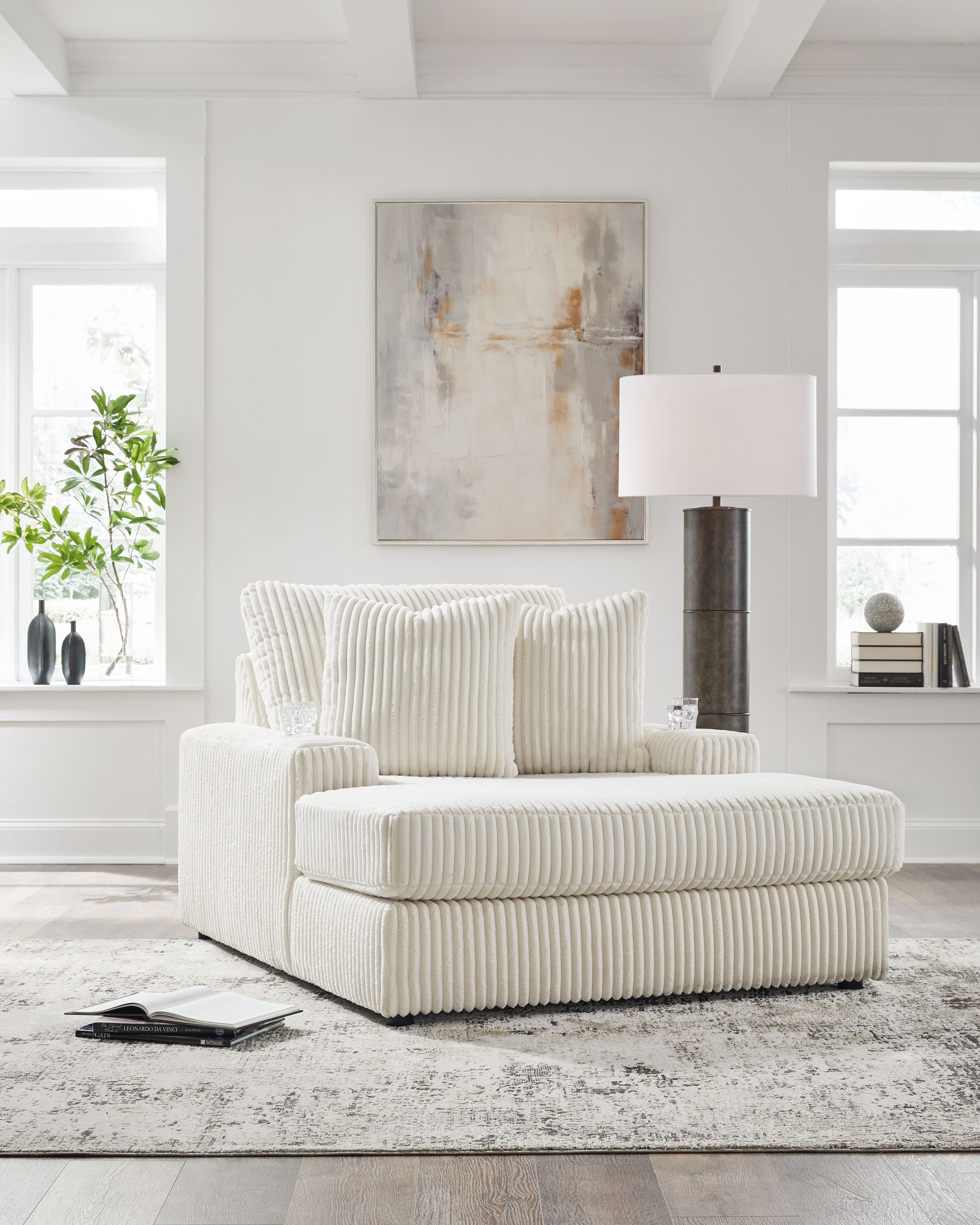 Corduroy chaise lounge chair in light beige with ribbed texture and two back cushions.