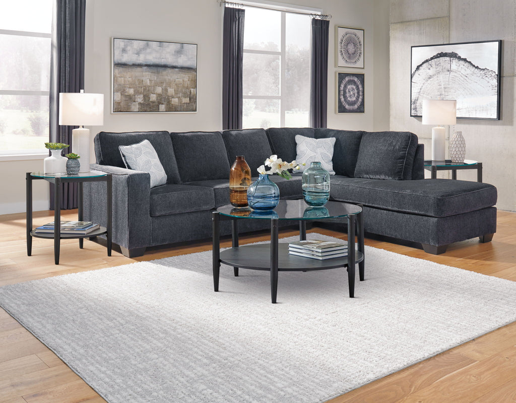 Dark gray sectional sleeper sofa with chaise, tufted back, and decorative cushions