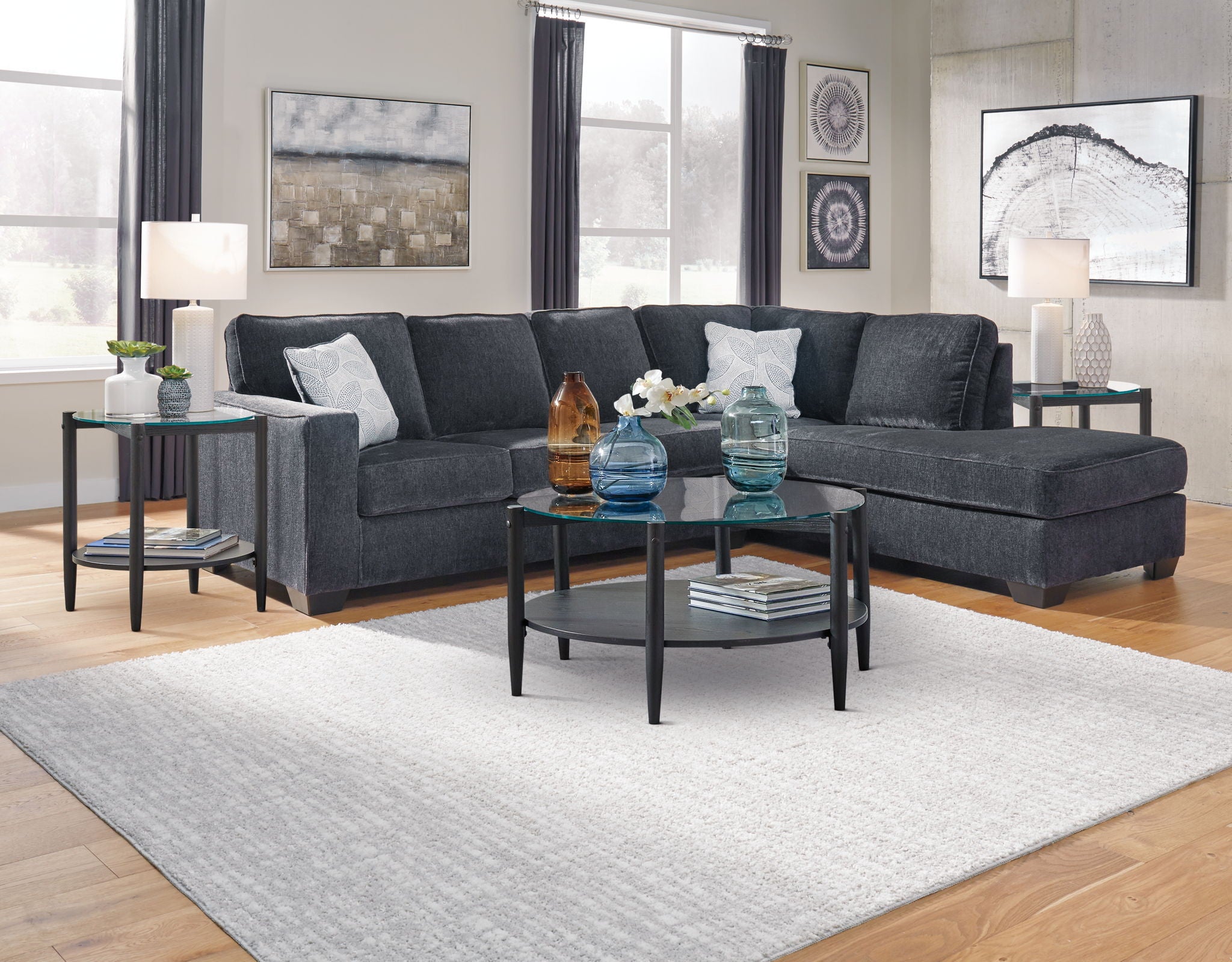 Dark gray sectional sleeper sofa with chaise, tufted back, and decorative cushions