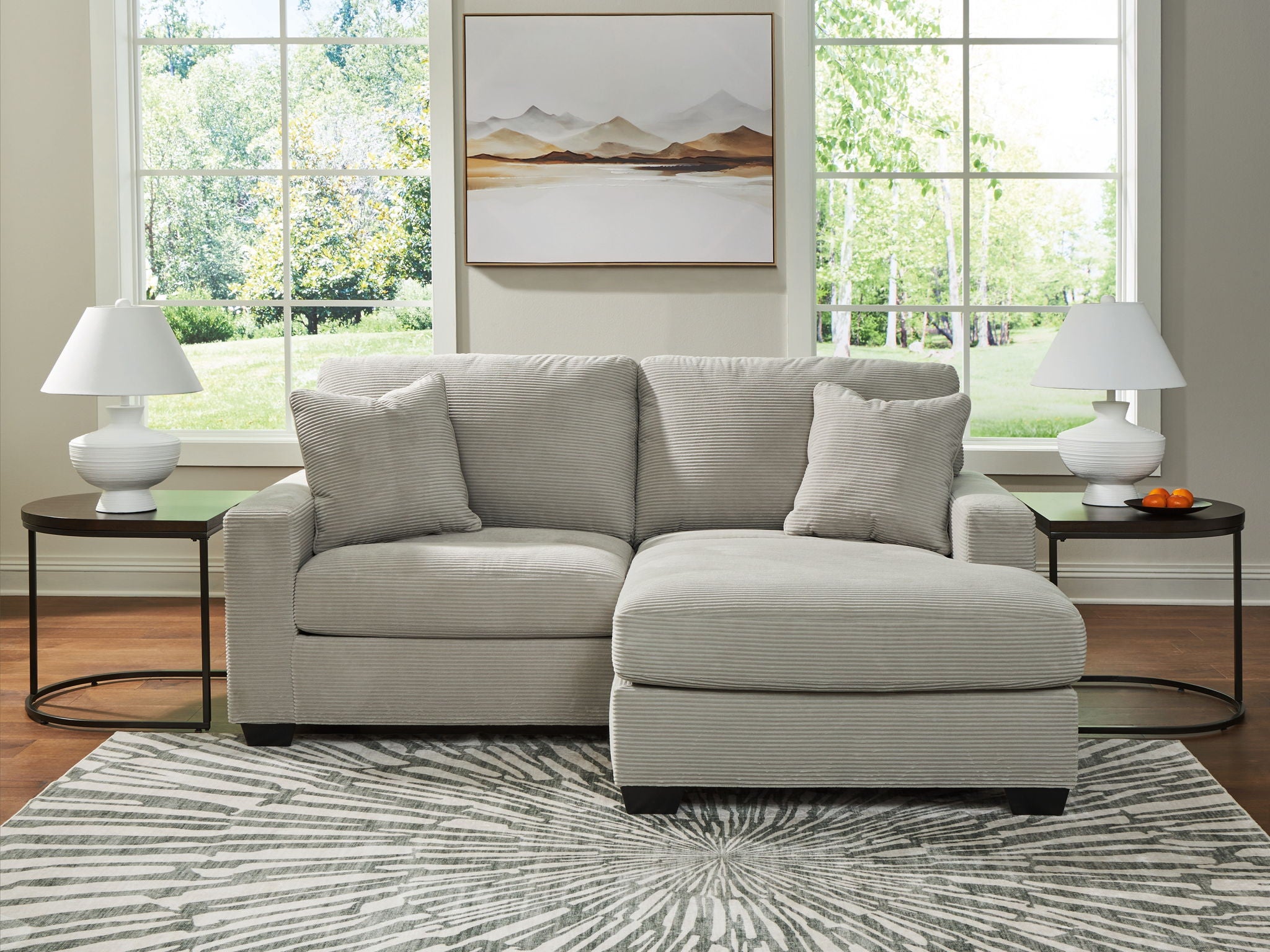 Gray sofa chaise with three back cushions and a chaise ottoman extension