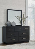 Black dresser with six drawers and metal bar handles, framed mirror