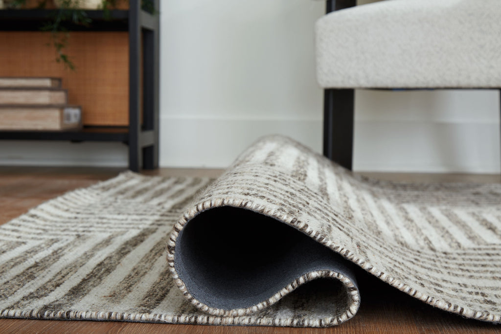 Gray chevron rug rolled edge showing underside and stitched border