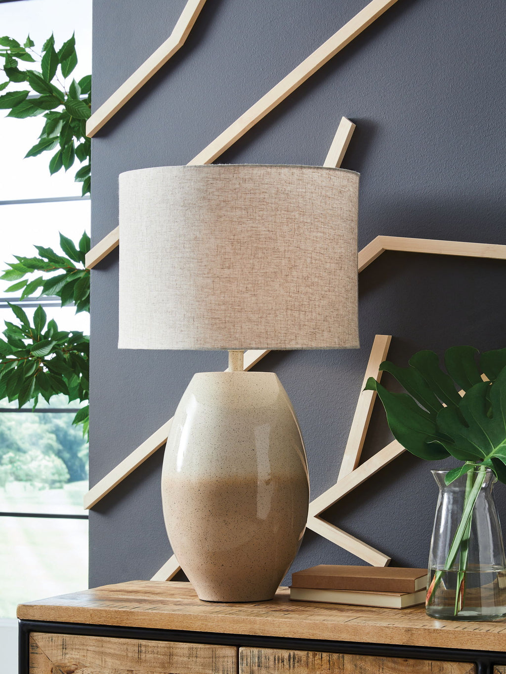 Cream beige table lamp with linen drum shade and speckled base on shelf