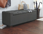 Gray upholstered storage bench with tufted top and padded armrests