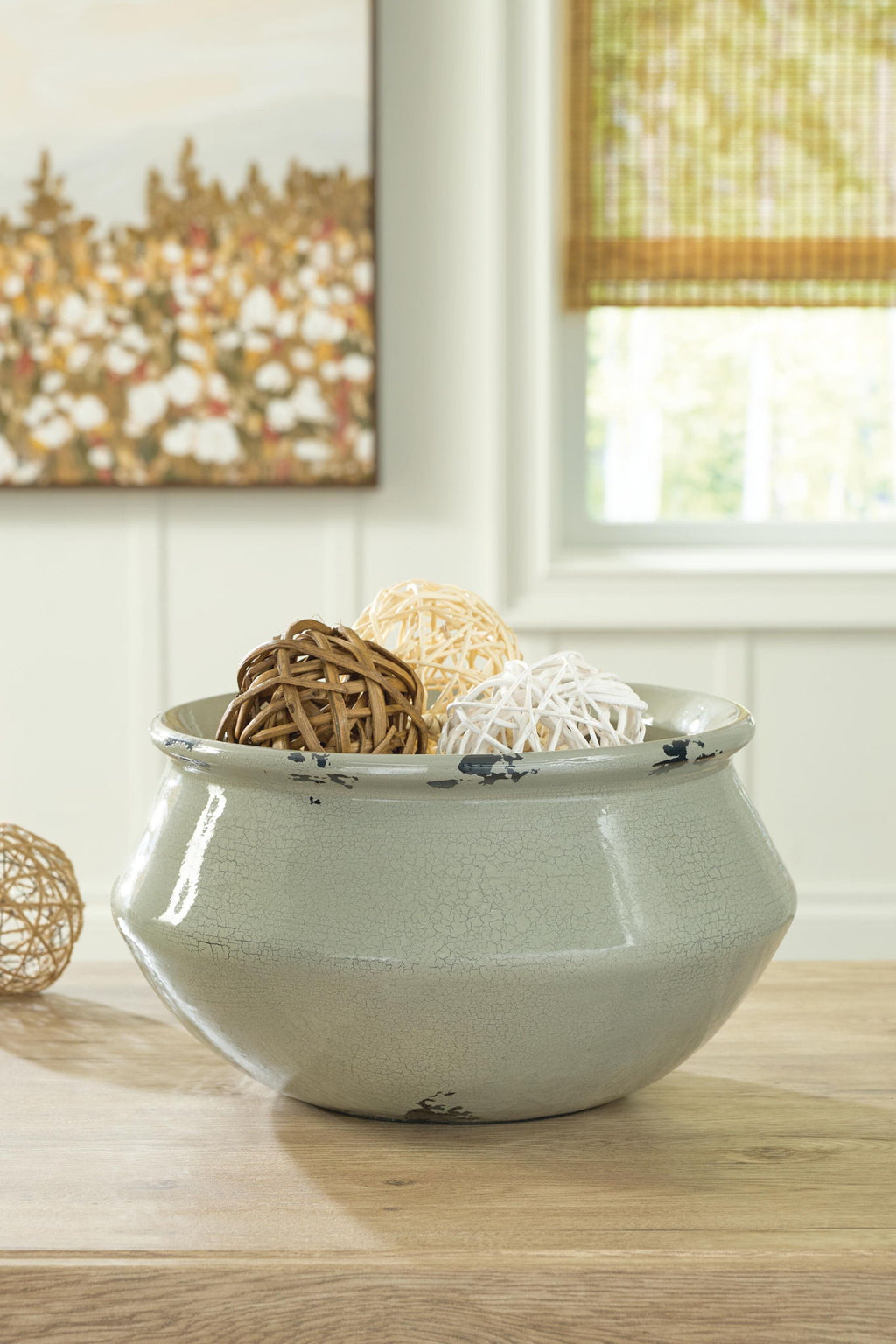Sage ceramic bowl with crackle glaze and black silhouette pattern, filled with decor