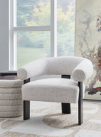 Light gray upholstered accent chair with rounded arms and dark legs